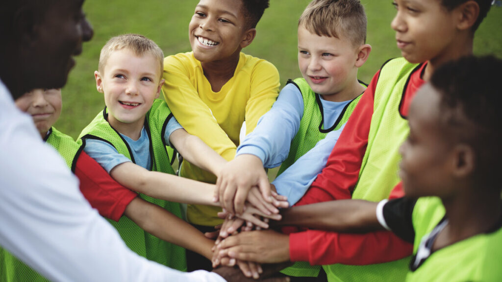 Une equipe de jeunes footballeurs rassemblee avec son educateur avant un match de tournoi